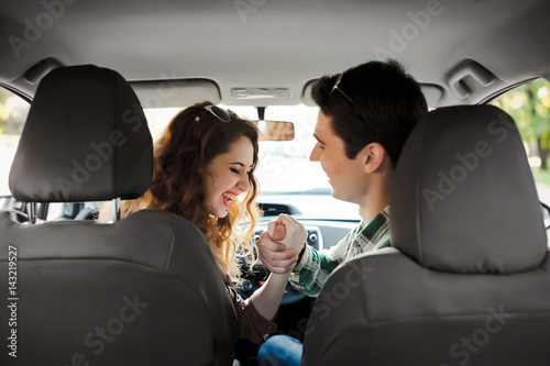 young couple having fun inside a car