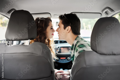 young couple having fun inside a car