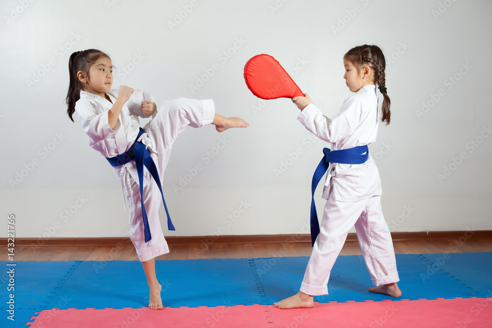 Two little girls demonstrate martial arts working together Two little girls demonstrate martial arts working together
