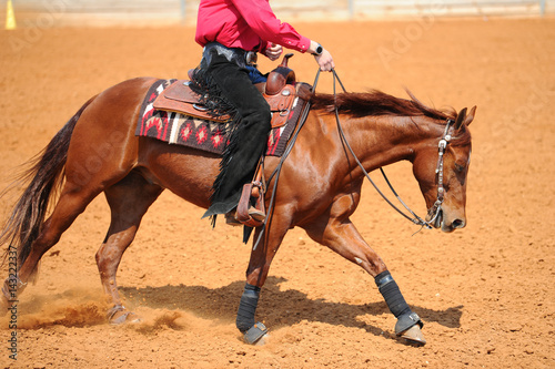 A side view of a western rider on horseback
