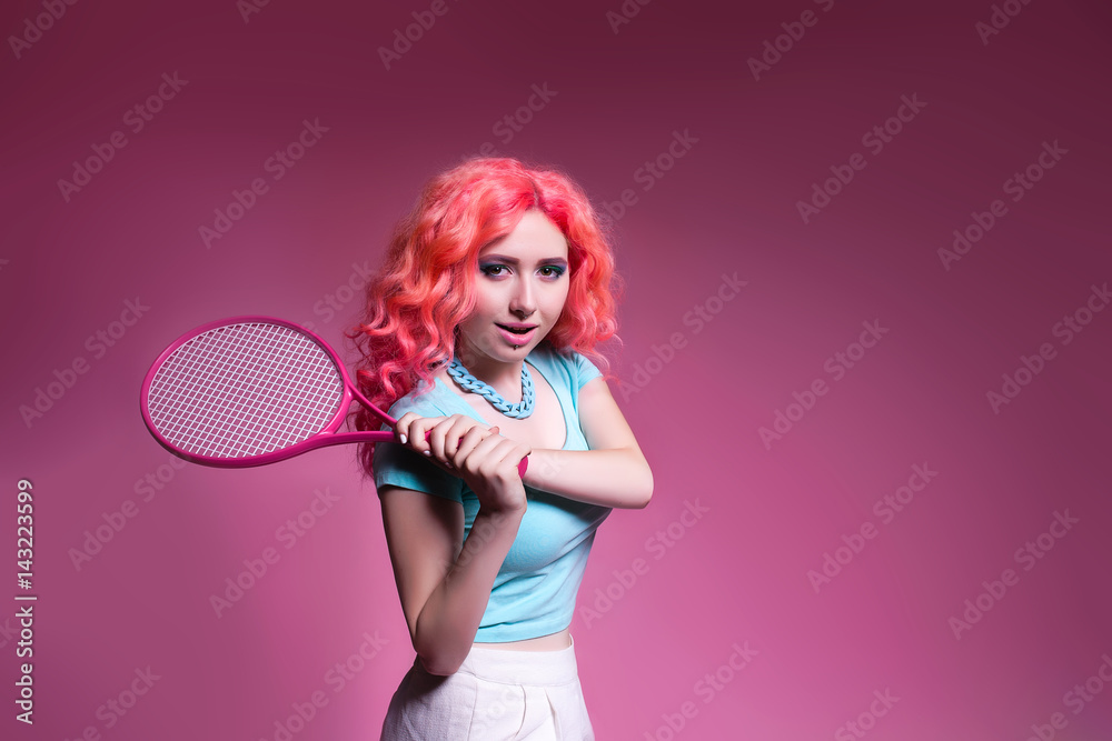 Girl with pink hair plays tennis on a pink background