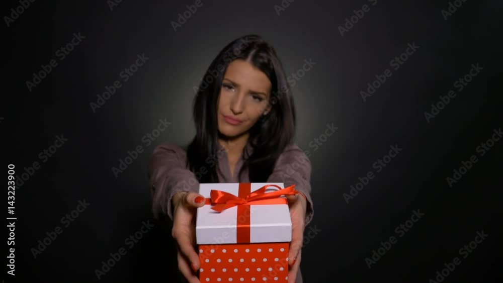Woman with gift in her hands refuses it and gives it back upset Woman with gift in her hands refuses it and gives it back upset
