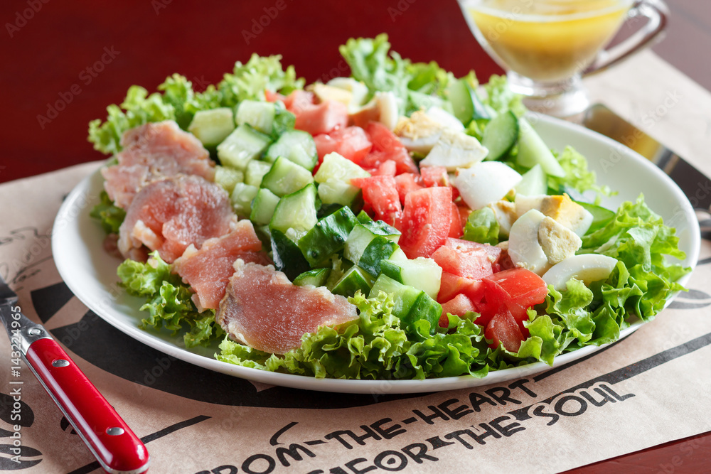 cobb salad - traditional american food, hearty meal of salmon, eggs, cucumber, avocado and lettuce leaves with mustard dressing cobb salad - traditional american food, hearty meal of salmon, eggs, cucumber, avocado and lettuce leaves with mustard dressing