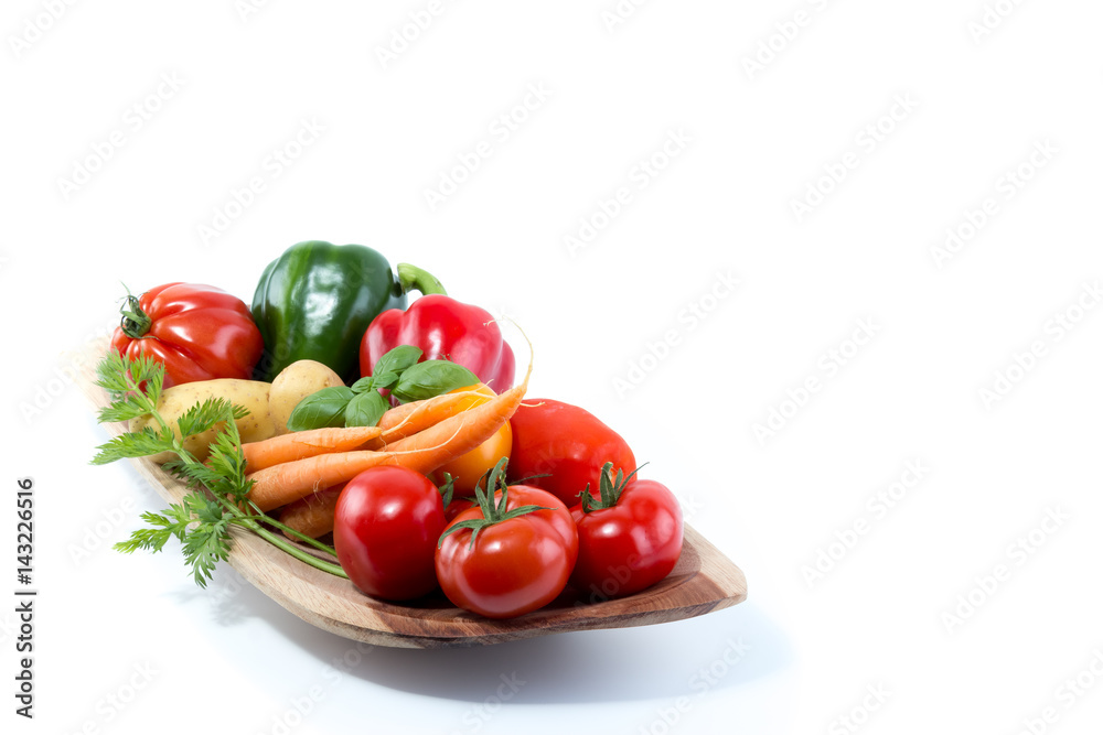 Fresh vegetables in a handmade natural real wood bowl - tomatoes, carrots, pepper, potatoes with white background Fresh vegetables in a handmade natural real wood bowl - tomatoes, carrots, pepper, potatoes with white background