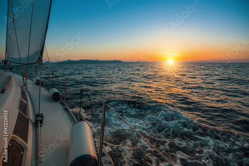 Sailboat with sails set to Sea at full speed at amazing sunset. Luxury cruise yacht. .