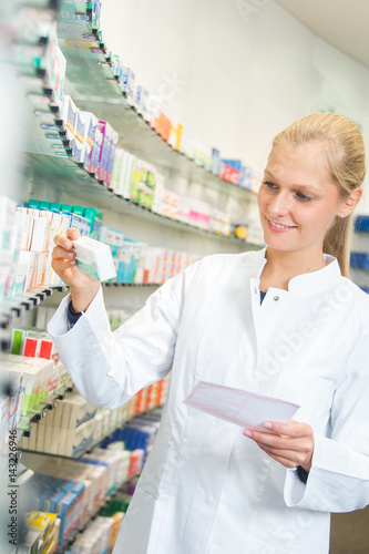 Junge Apothekerin sucht Medikamente aus einem Regal