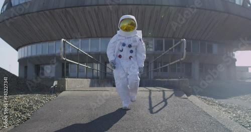 Funny astronaut doing a dance as he walks away from mission control building photo