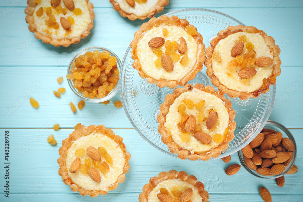 Dessert stand with delicious crispy tarts on wooden background