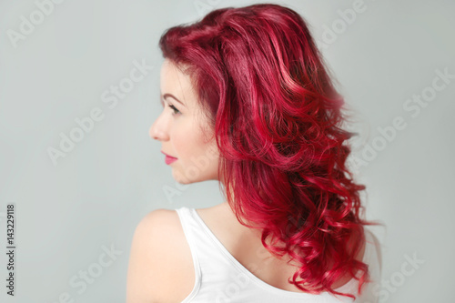 Beautiful young woman with dyed curly hair indoors