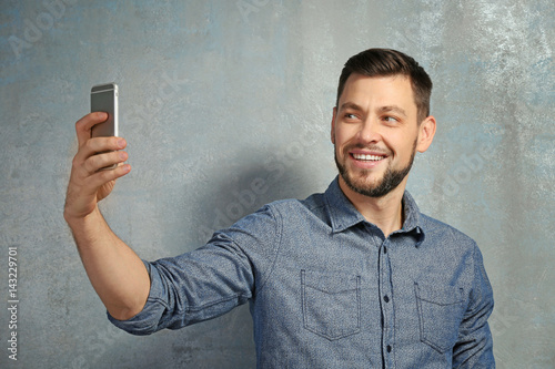 Young man taking selfie whi...