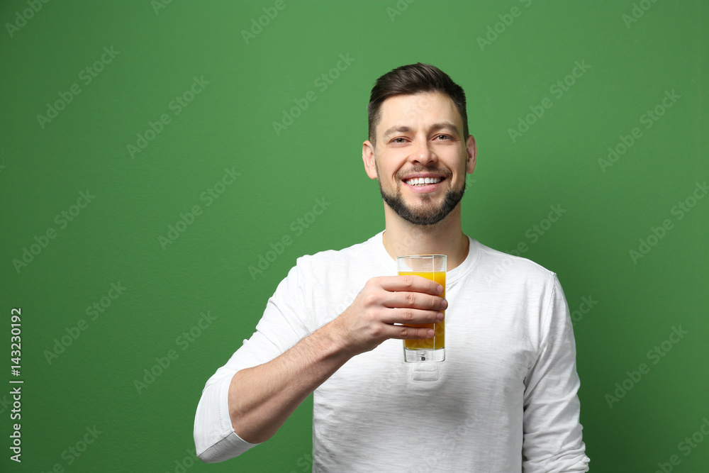 Handsome man posing with juice on color background Handsome man posing with juice on color background