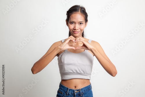 Young Asian woman show heart hand sign. © halfbottle