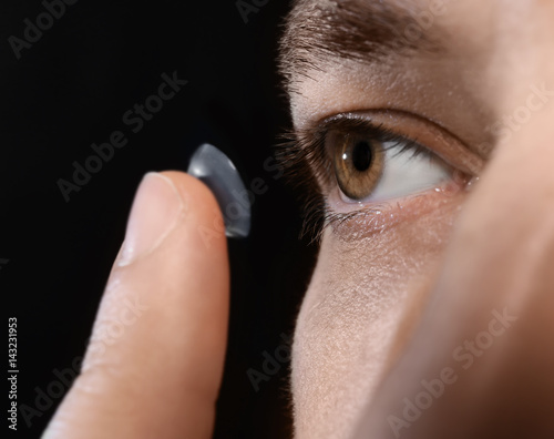 Young man putting contact l...