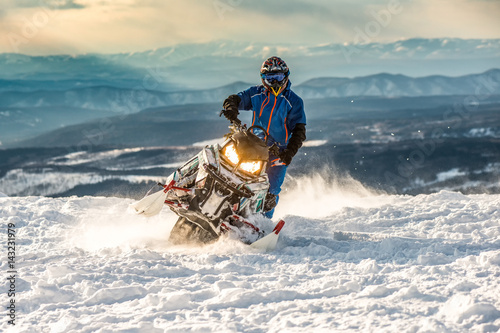 Rider on the snowmobile in the mountains. active drive photo