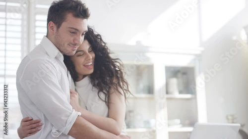  Happy affectionate couple relaxing at home, looking at laptop computer photo