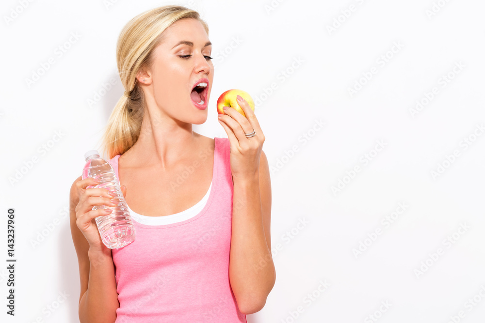 Happy young woman holding apple and water Happy young woman holding apple and water