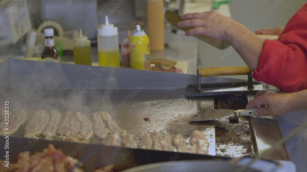 Deli sandwich being removed from grill near raw bacon Deli sandwich being removed from grill near raw bacon