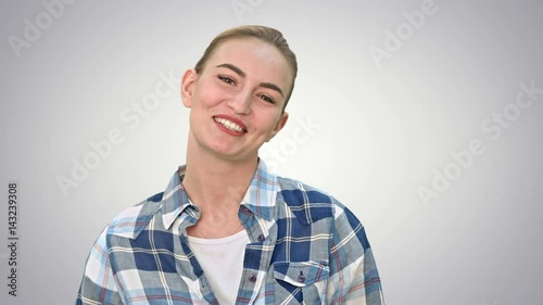 Cheerful young woman talking to a camera on white background.