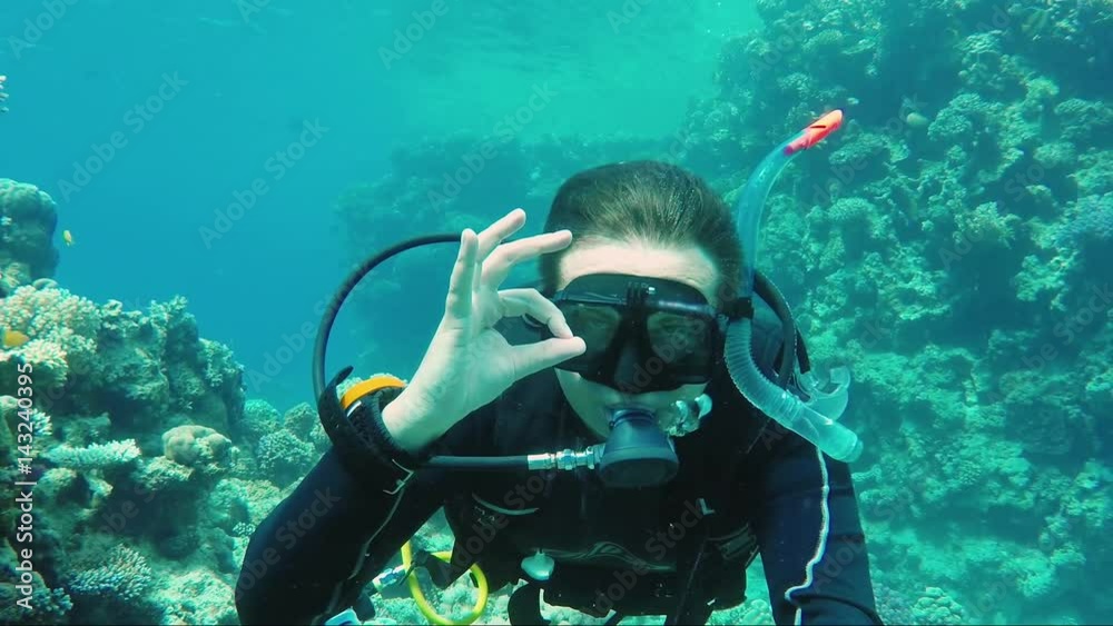 Great vacation and diving in the warm sea. The scuba diver signs the okay sign and takes himself off on a video of Self pin