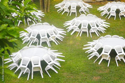 Stock Photo - White plastic table and chairs outside in a garden on green lawn