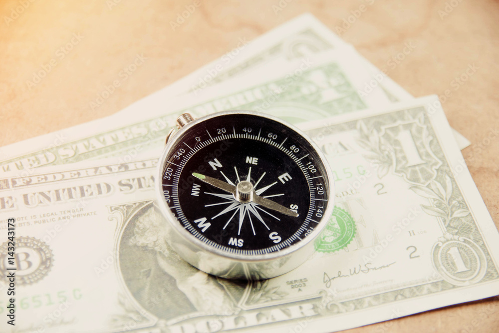 Magnetic compass with pocket money on work table, ready for traveling.
Magnetic compass with pocket money on work table, ready for traveling.