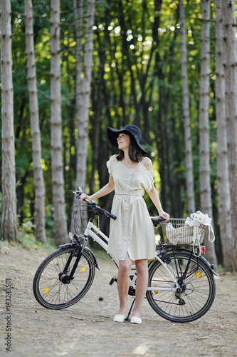 Young woman against nature background with bike