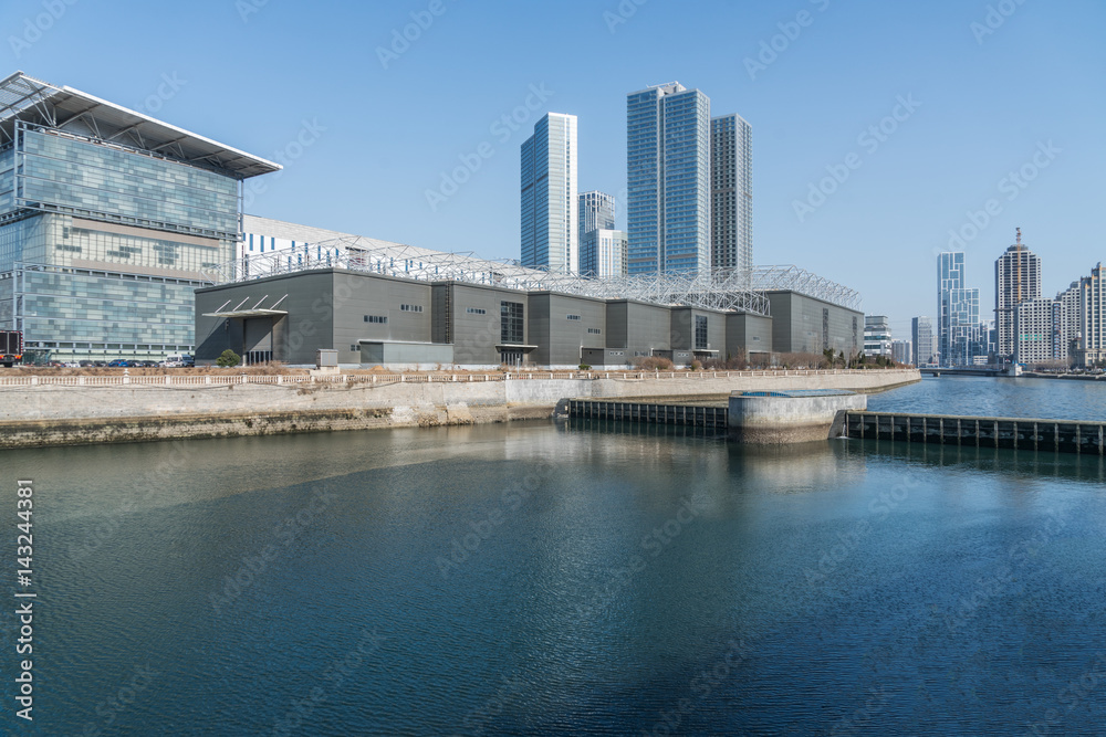 River And Modern Buildings Against Sky,reflection of cityscape in river,shot in Shanghai,China.