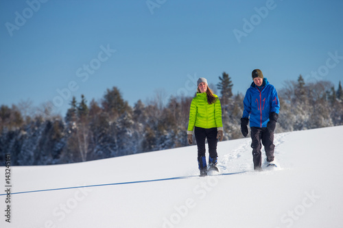 Obraz na płótnie Couple Snowshoeing in fresh snow w salonie