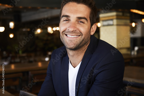 Happy guy smiling in cafe, portrait