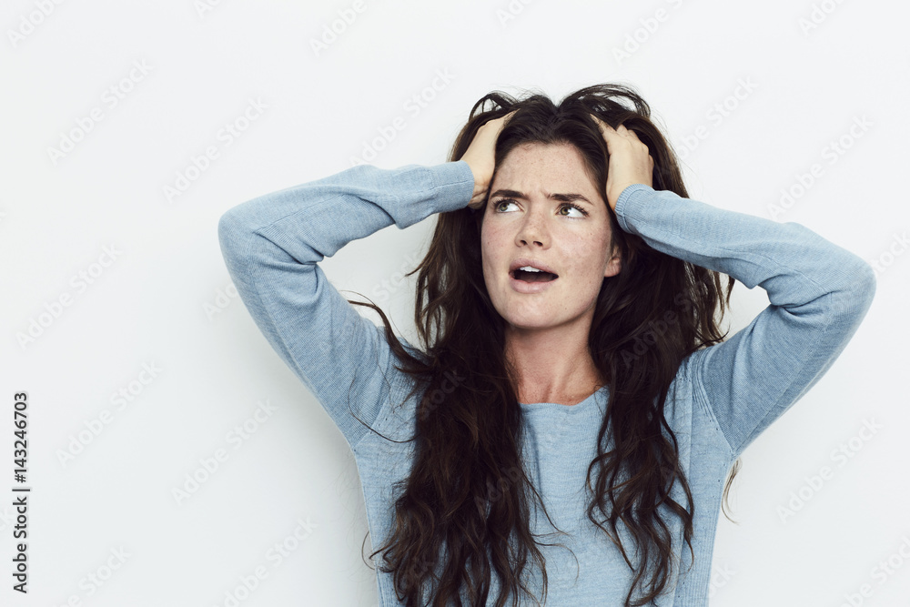 Confused girl with head in hands, looking up Confused girl with head in hands, looking up