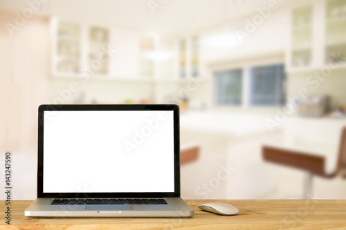 Laptop blank screen on wood table in kitchen room. For Graphic montage.