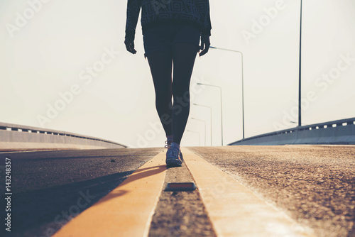 silhouette woman  walking on street in the sunset.