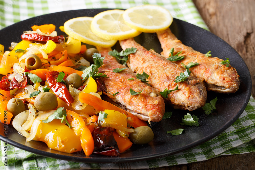 Roasted red mullet with stewed vegetables, lemon and greens close-up. Horizontal Roasted red mullet with stewed vegetables, lemon and greens close-up. Horizontal