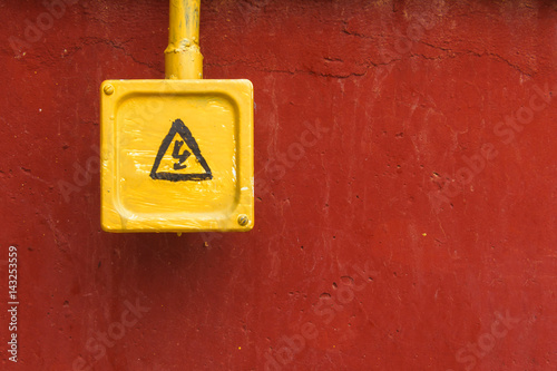 Yellow danger sign on the red wall