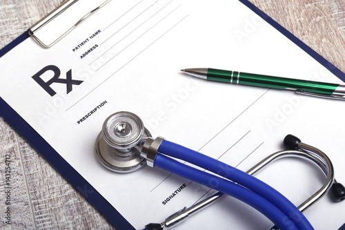 Closeup of a pils, stethoscope, pen on an rx prescription.