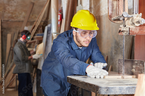 Schreiner arbeitet in Schreinerei mit Holz