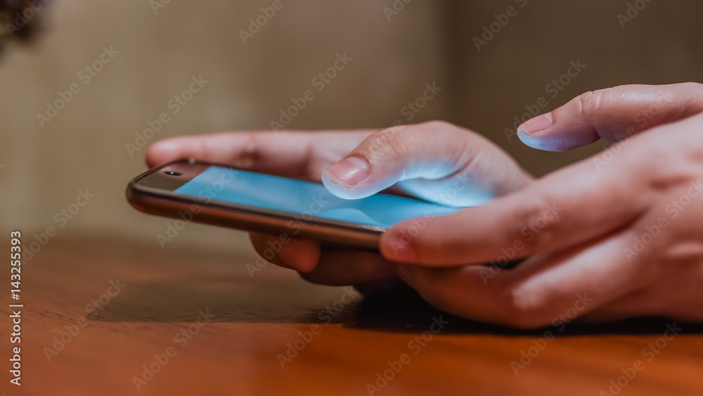 A woman's hand is playing a smartphone. A woman's hand is playing a smartphone.