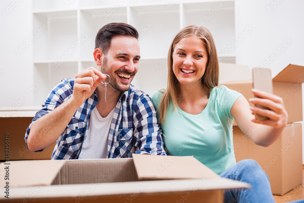 Young couple is moving in their new home. It's time for unpacking. Young couple is moving in their new home. It's time for unpacking.