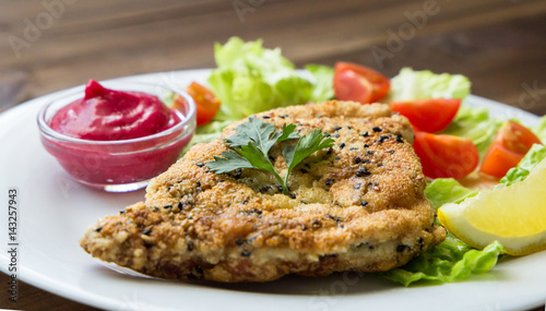 Homemade Breaded Schnitzel with salad and berry sauce