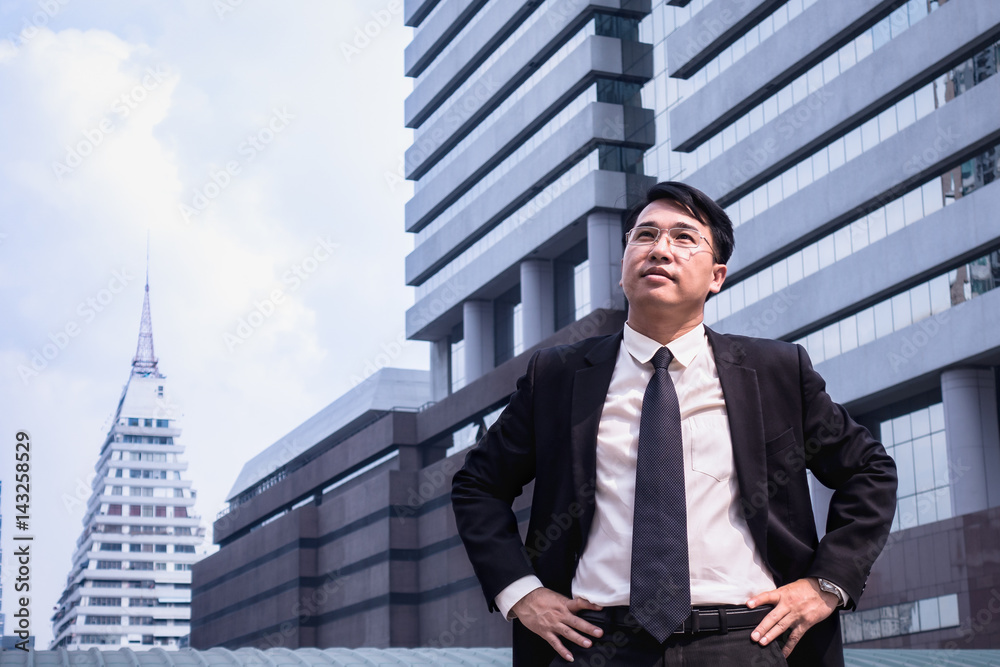 Confident Asian Businessman standing and looking at city for vision concept Confident Asian Businessman standing and looking at city for vision concept