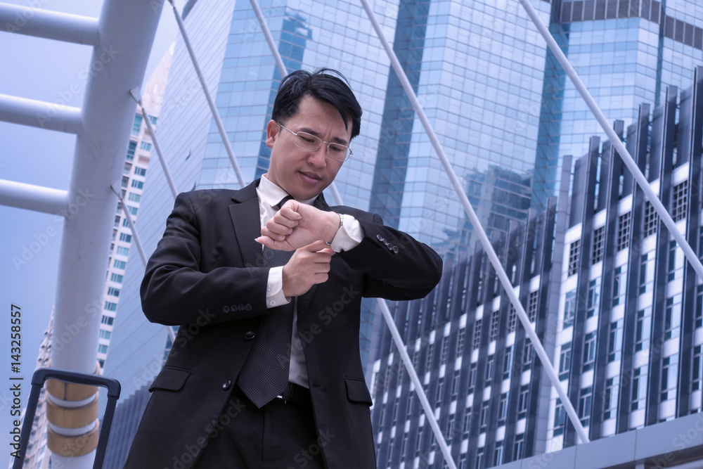 Asian Confident business man watching time for appointment and modern city background, time management concept Asian Confident business man watching time for appointment and modern city background, time management concept