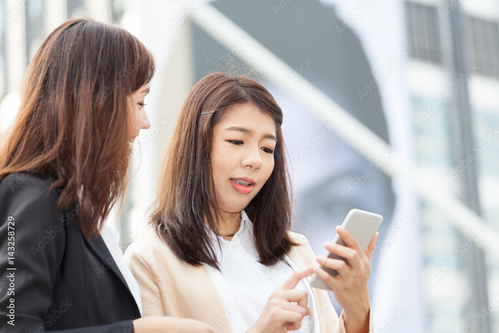 business woman using a cell phone with colleague and discussion topic on business conceptual business woman using a cell phone with colleague and discussion topic on business conceptual