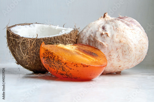 Fruits: coconut, persimmon, greyfruit on a white background