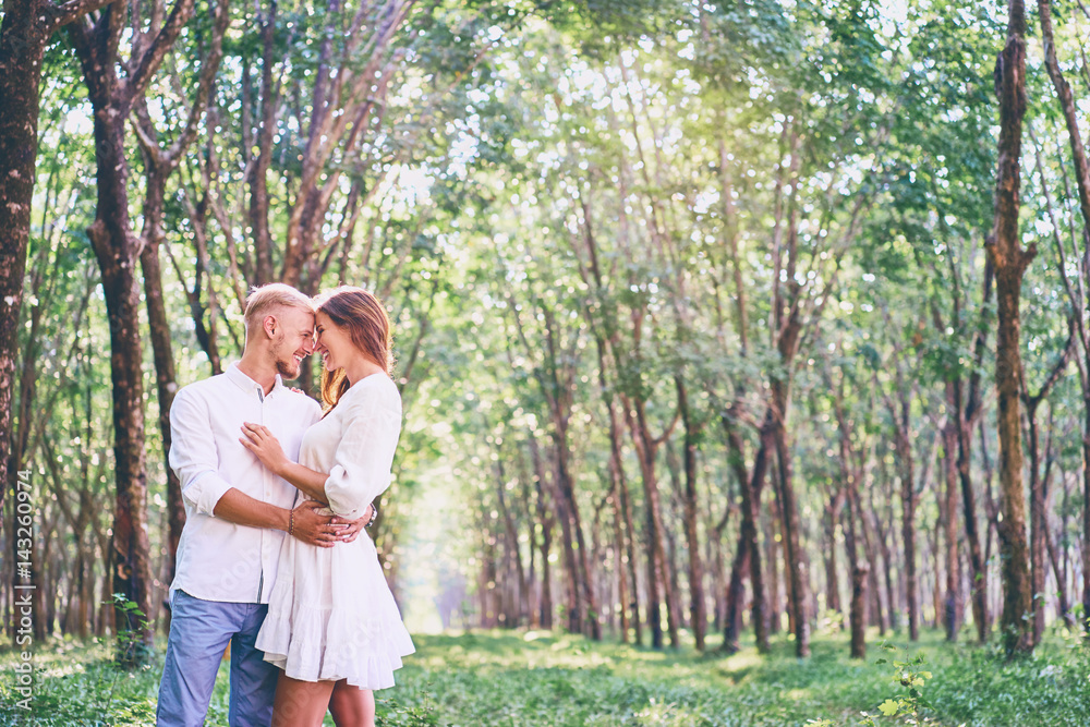 Naklejka premium Love and tenderness. Beautiful young loving couple embracing in green garden. Romantic dating.