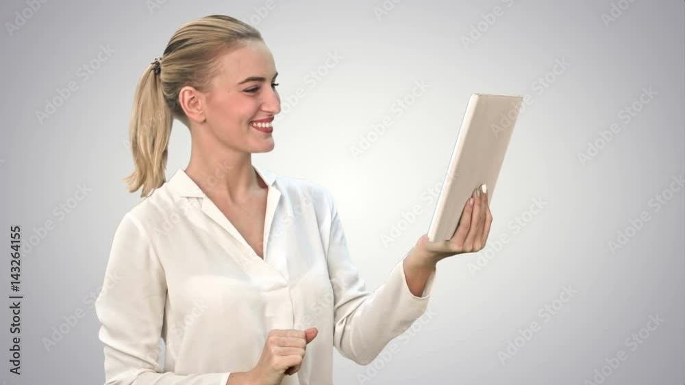 Positive businesswoman is talking on the skype with partners on tablet on white background. Positive businesswoman is talking on the skype with partners on tablet on white background.