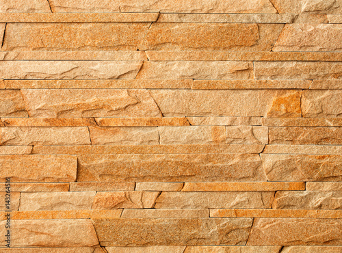 Wall stone mosaic made of golden sandstone texture