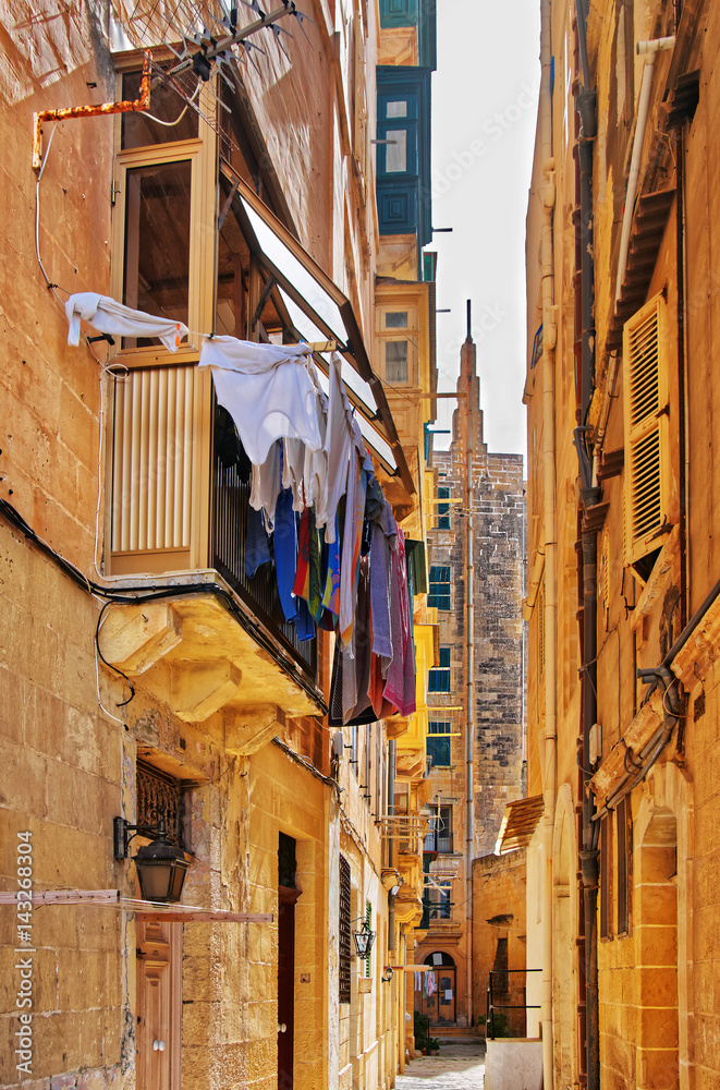 Old street with traditional houses and balconies in Valletta