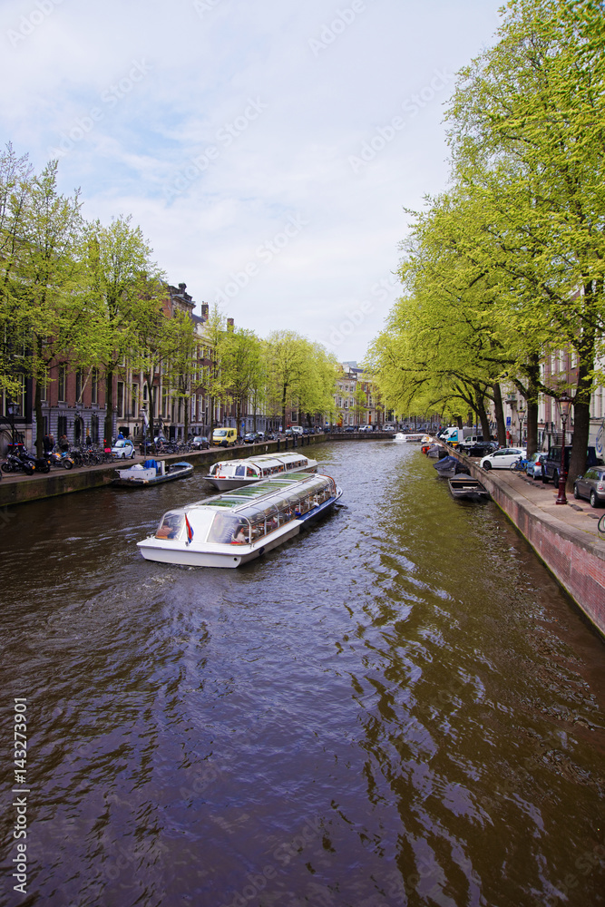 Boats on canal of Amstel River and buildings in Amsterdam