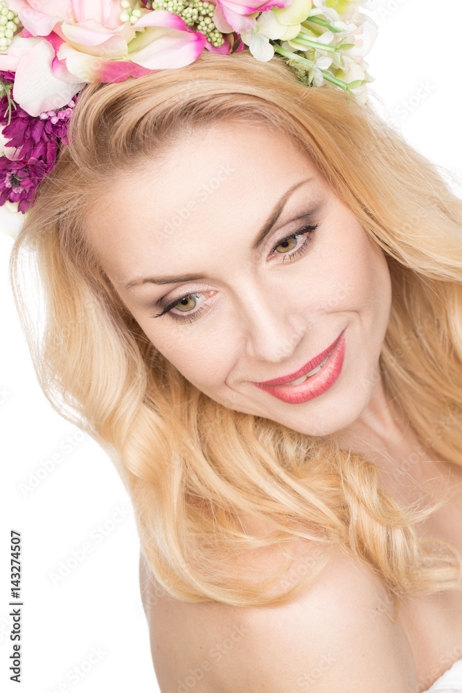 Magnetic nature. Top view portrait of a beautiful mature female looking away smiling wearing a flower wreath isolated on white