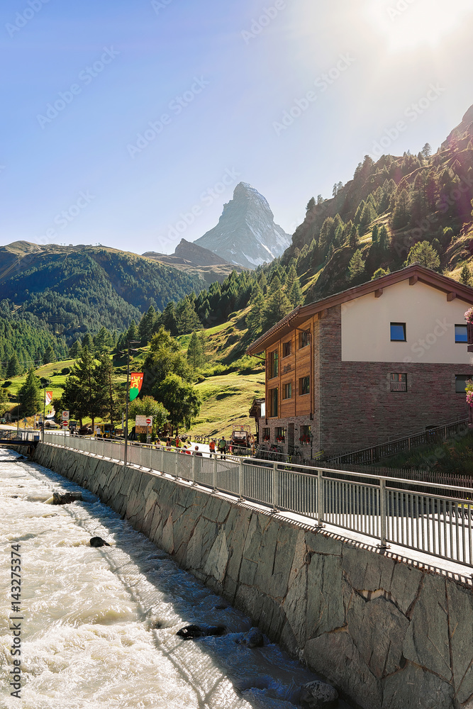 Fototapeta premium Traditional Swiss chalets and Gornera River and Matterhorn summit